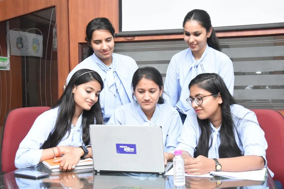 Women reviewing work together on a laptop in Jaipur, India