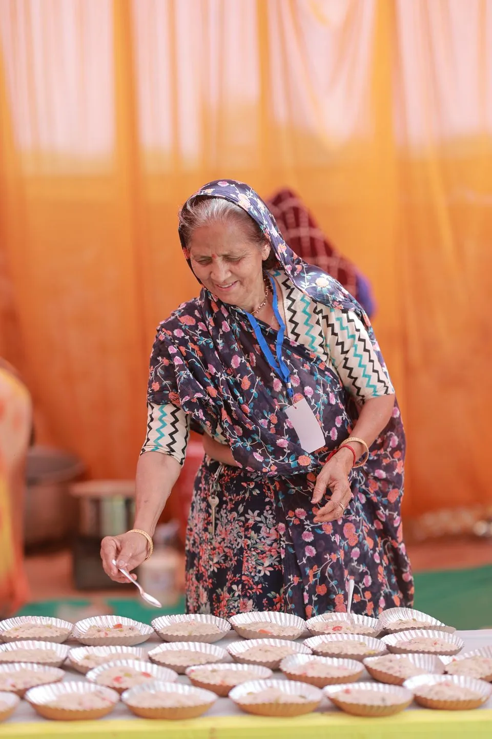 Woman serving food at a community gathering in India