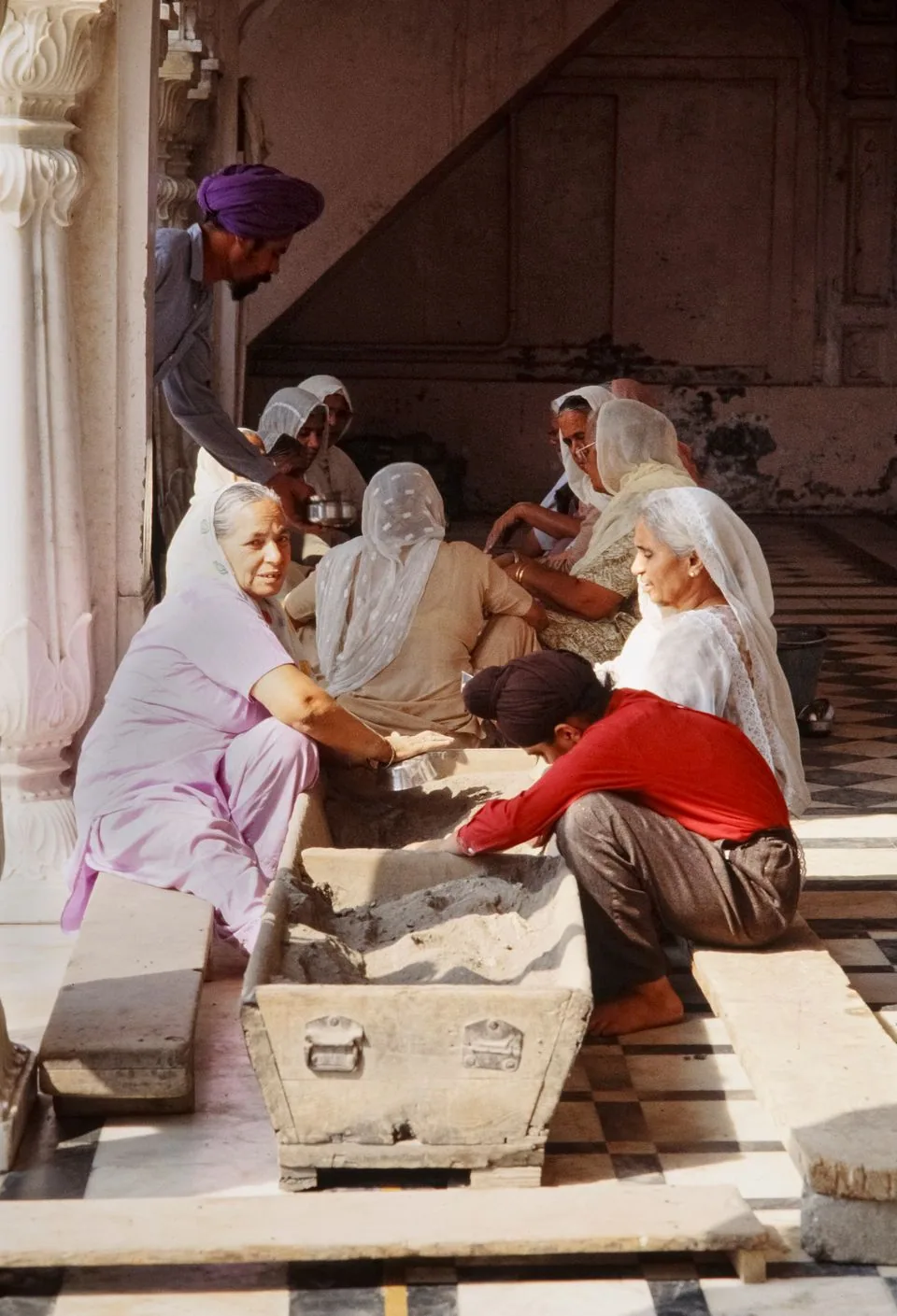 Women preparing food together for community service in India