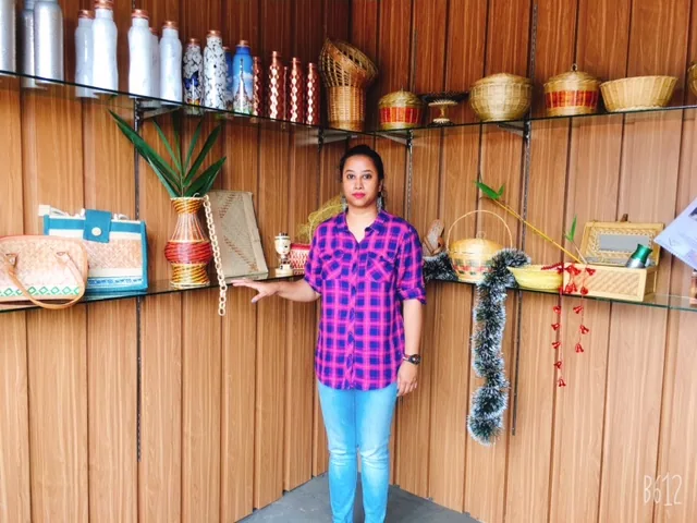 Artisan standing beside a display of handmade baskets and natural fibre products