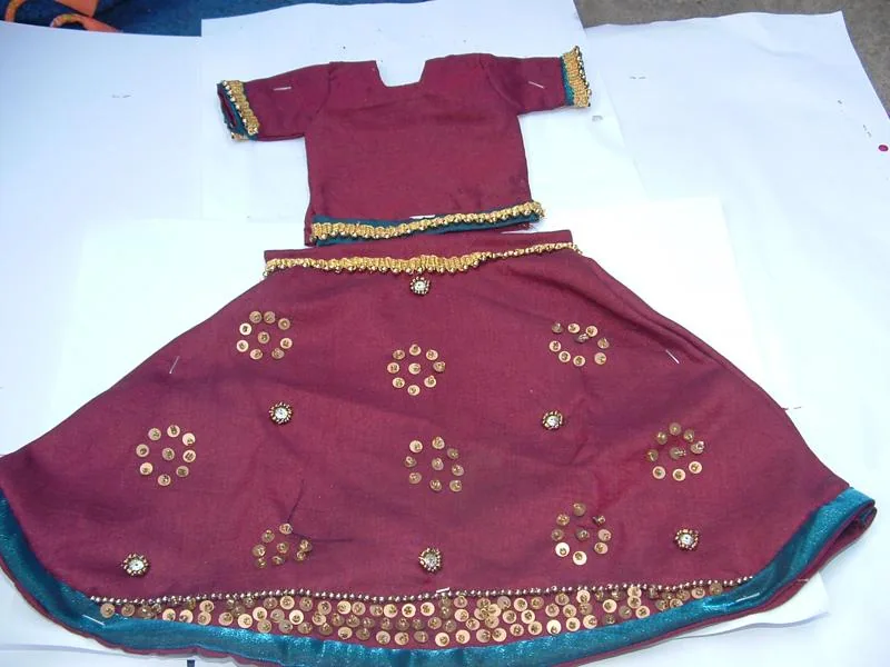 Maroon embroidered garment displayed as community craft work